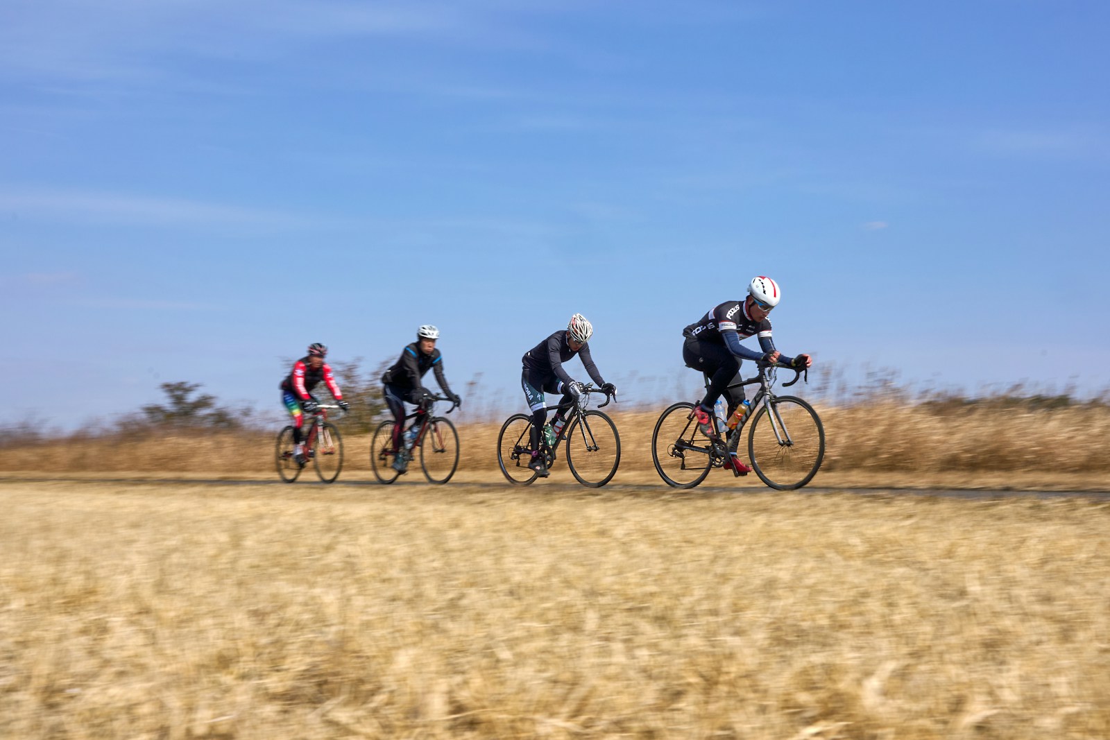 A group of people riding bikes down a dirt road